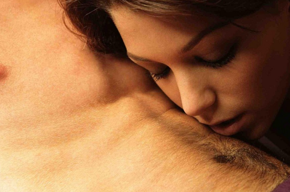 Женщина целует живот мужчине