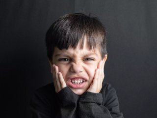 Чому дитина скрегоче зубами уві сні: що можуть означати нічні симптоми