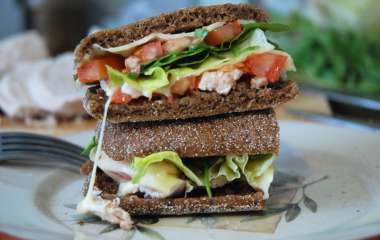 Сэндвич из черного хлеба с лососем, салатом-латуком и помидорами